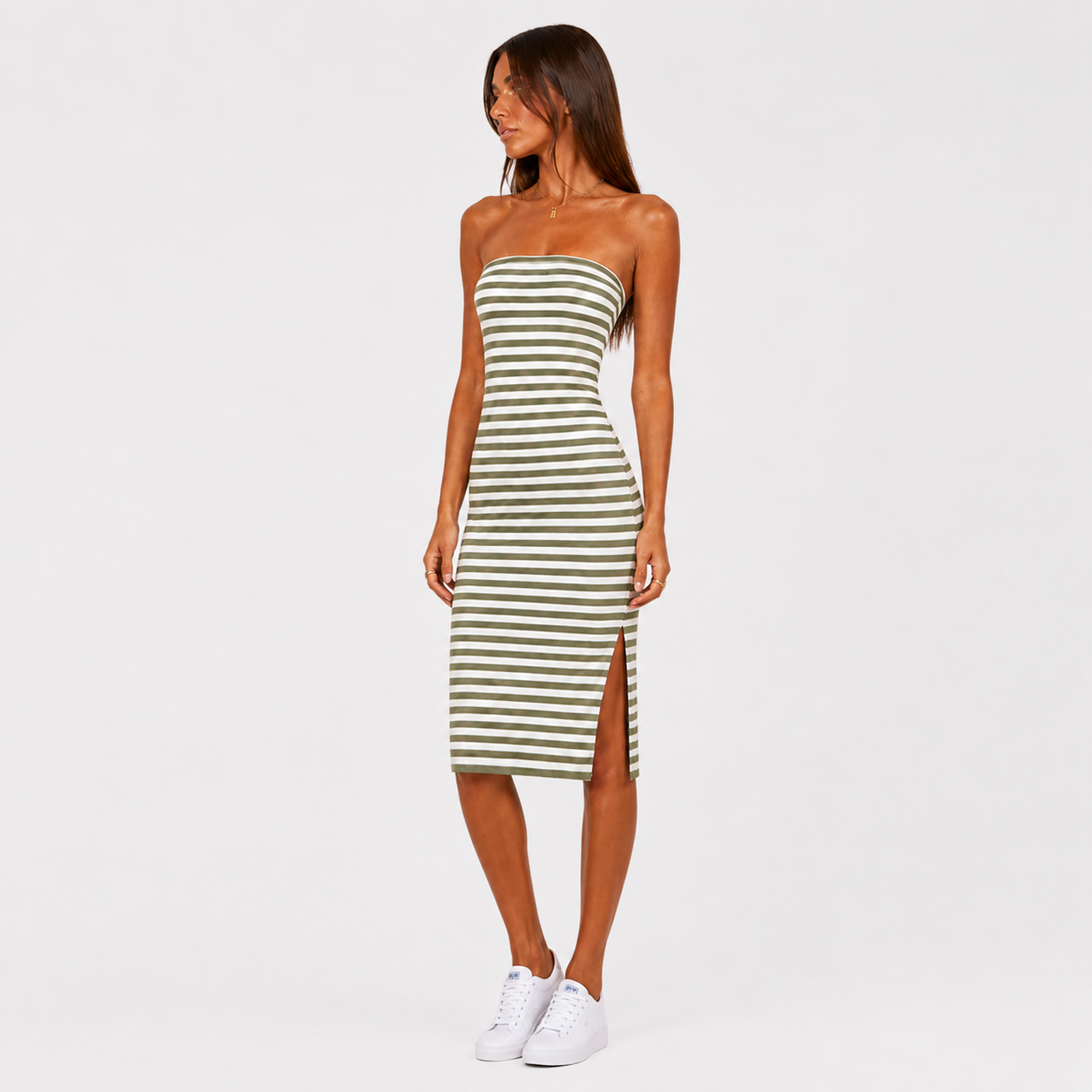 Woman wearing a strapless green and white striped dress on a white background